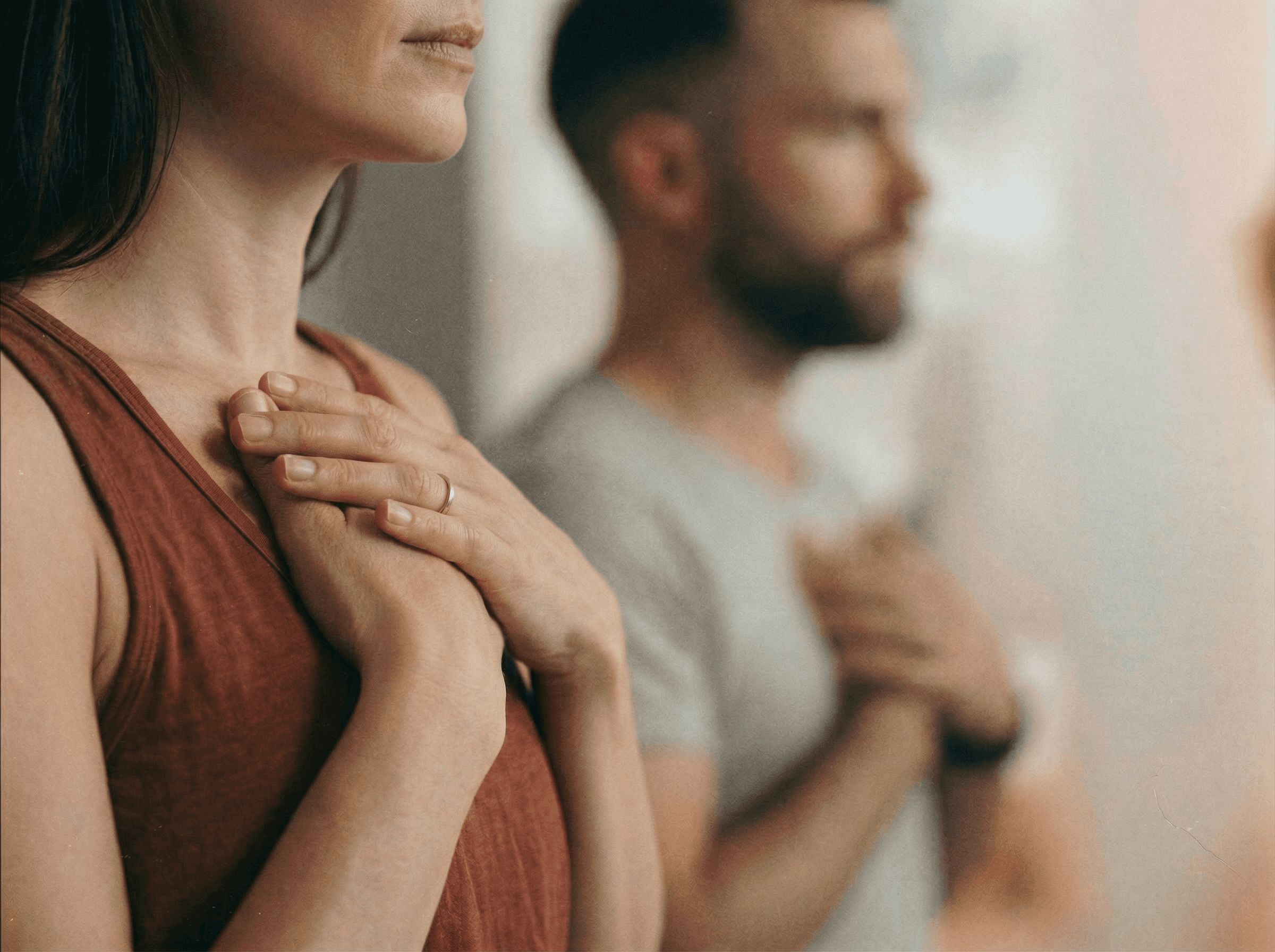 Zwei Personen mit den Händen auf dem Herzen in einer ruhigen Yogastunde